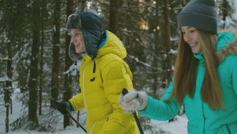 Portrait-of-a-married-couple.-A-man-in-a-yellow-jacket-and-a-woman-in-a-blue-jumpsuit-in-the-winter-in-the-woods-skiing-in-slow-motion